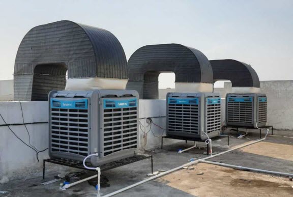 Workers staying comfortable with industrial air cooler in large commercial space