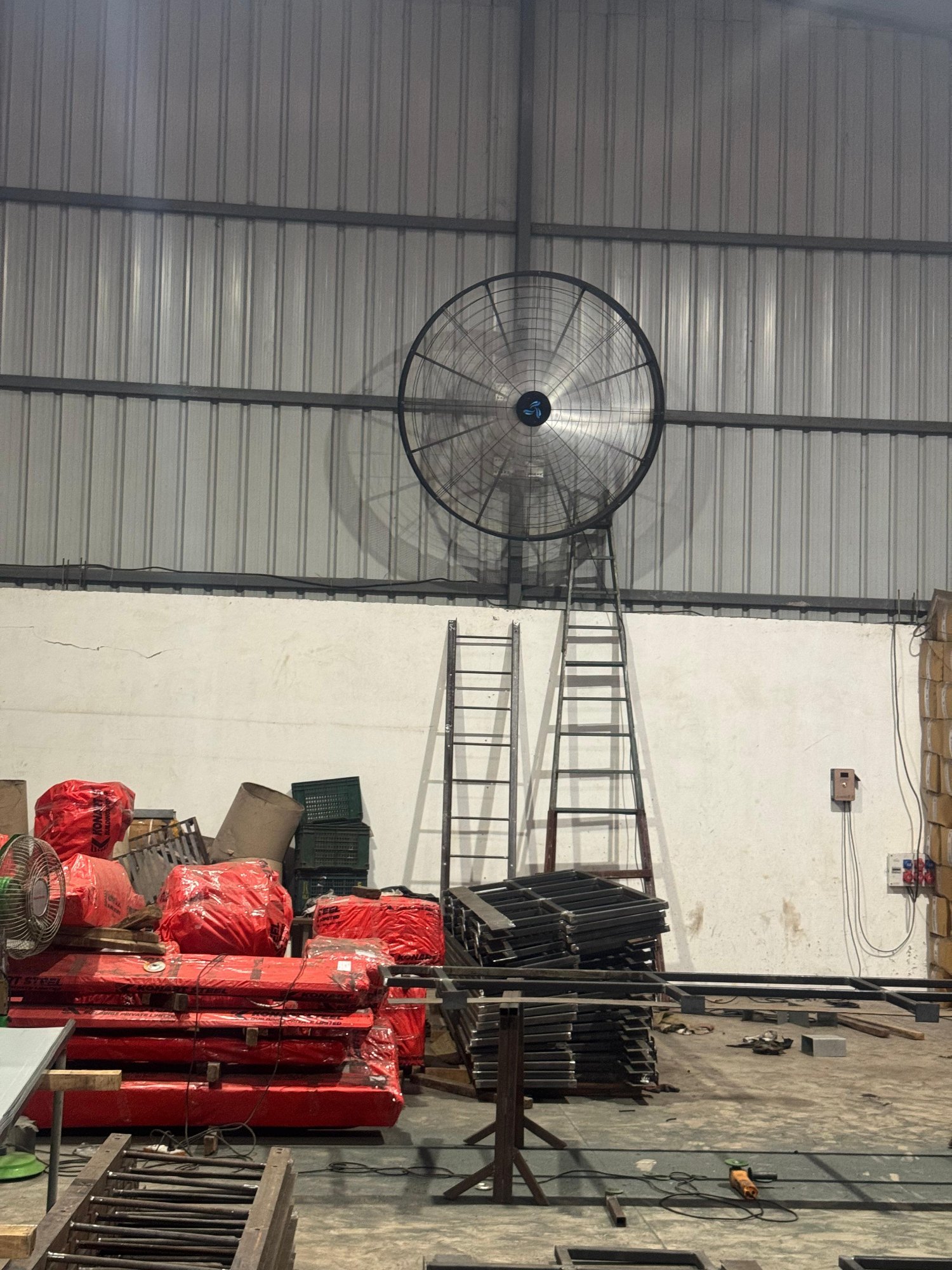 Industrial wall mount fan installed in a large factory for effective air circulation